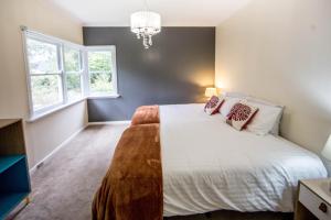 a bedroom with a white bed and two windows at Welcome on Wellington in Warburton