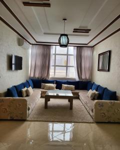 ein Wohnzimmer mit einem Sofa und einem Tisch in der Unterkunft Résidence De Luxe AL Manzah in Al Hoceïma