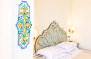 1 dormitorio con cama y espejo en la pared en Hotel Terme Tritone Resort & Spa, en Isquia