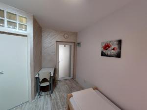 a room with a bed and a desk and a window at Apartments Sofija in Niš