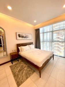 1 dormitorio con cama y ventana grande en Tranquility in the Midst of Vibrance en Nairobi