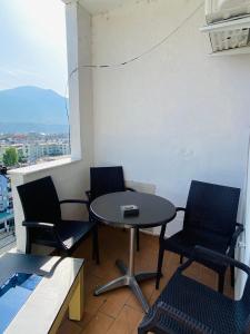 a table and chairs in a room with a window at Welcome home in Kukës