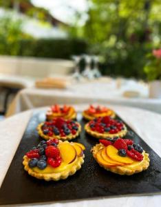 four pies with fruit on a tray on a table at Hotel Ristorante Mariuccia Varese in Varese