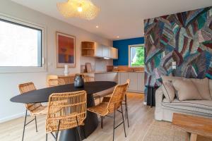 a kitchen and living room with a table and chairs at Ty Glaz - Maison à 900m de la plage in Fouesnant