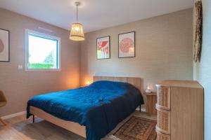um quarto com uma cama azul e uma janela em Ty Glaz - Maison à 900m de la plage em Fouesnant