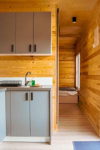 a kitchen with a sink and a room with a bed at Arche Siedlisko Piłka Boisko 