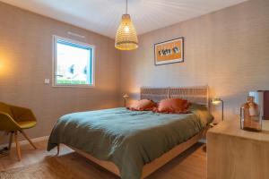 1 dormitorio con 1 cama, 1 silla y 1 ventana en Ty Bej - Maison à 900m de la plage, en Fouesnant
