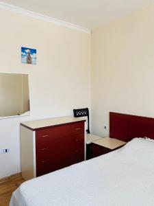 1 dormitorio con cama, escritorio y tocador en Welcome home, en Kukës