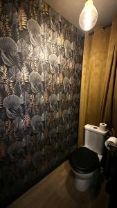 a bathroom with a toilet and a shower curtain at LA BLACK ROOM / Les suites romantiques à Honfleur centre historique in Honfleur
