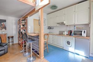 eine Küche mit einem Tisch und einer Waschmaschine in der Unterkunft Bamboos Garden - Appartement climatisé in Malakoff