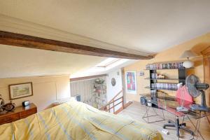 Schlafzimmer mit einem Bett und einem Schreibtisch mit einem Ventilator in der Unterkunft Bamboos Garden - Appartement climatisé in Malakoff