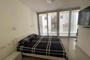1 dormitorio con cama y ventana grande en luxury boutique apartment 2BR With balcony on the sea, en Haifa
