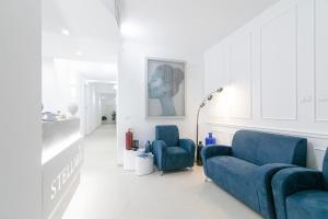 un soggiorno con 2 sedie blu e un divano di Stellaris Apartrooms a Termoli