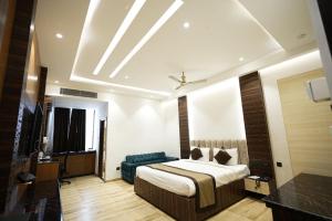 a bedroom with a bed and a blue couch at hotel the lilli villas in Alambagh