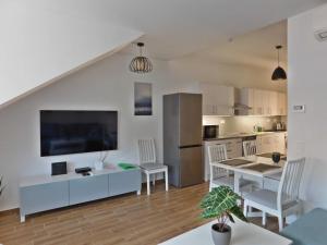 cocina y sala de estar con mesa y sillas en Berki Apartman, en Körmend