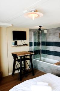 um quarto com uma mesa e uma banheira em Floatel - de Schans Alphen em Benedeneind