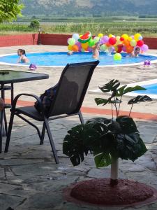 uma cadeira em frente a uma piscina com crianças na água em ΠΕΡΙ ΑΝΕΜΩΝ em Zérvi