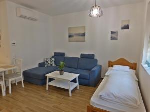 a living room with a blue couch and a table at Berki Apartman in Körmend