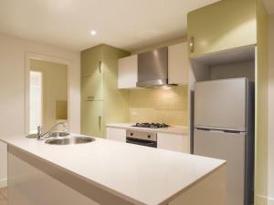 a kitchen with a sink and a refrigerator at Liberty bay holiday Spacious two bedroom, two bathroom with sea views in Glenelg