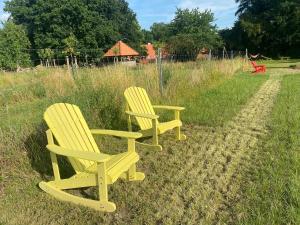 two yellow chairs sitting in the grass in a field at Fuchsbau in Walsrode