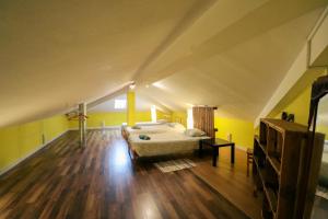 a bedroom with a bed and yellow walls and wooden floors at The Maverick Surfvillas in Lourinhã