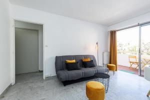 a living room with a gray couch and a table at Martelly furnished flat in Antibes