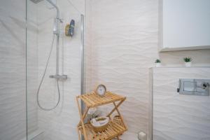 a bathroom with a shower with a clock on a stand at Sensations - Studio dans le quartier daffaires in Rueil-Malmaison