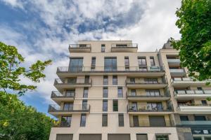 a tall building with windows and a cloudy sky at Sensations - Studio dans le quartier daffaires in Rueil-Malmaison