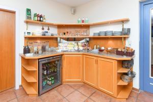 a kitchen with orange cabinets and a counter with drinks at Hotel-Pension Störtebeker in Bensersiel