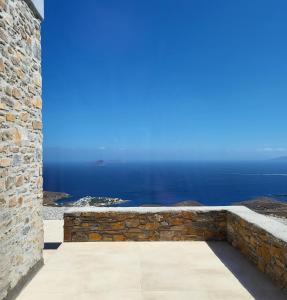 a view of the ocean from a stone wall at Thermyes Villas 3 in Kithnos