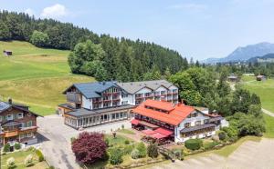 an aerial view of a large house in the mountains at Wohlfühlhotel Frohsinn in Fischen