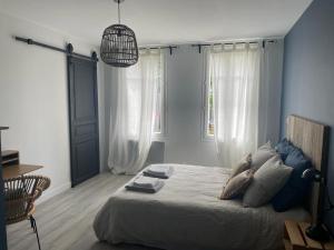 um quarto com uma cama e uma luz pendente em Charmante Echoppe en pierre proche gare em Libourne
