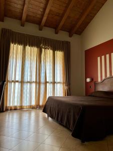 a bedroom with a bed and a large window at Hotel Ristorante Mariuccia Varese in Varese
