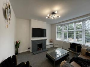 sala de estar con chimenea y TV de pantalla plana en Modern, 3Bedroom, Free Parking, Central en Oxford