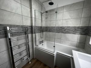 a bathroom with a bath tub and a sink at Modern, 3Bedroom, Free Parking, Central in Oxford