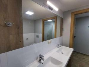 uma casa de banho com um lavatório e um espelho grande em Tanie Noclegi, kwatery, pokoje do wynajęcia , TARGI KIELCE em Kielce