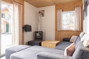 a living room with two couches and a tv at Feriendorf Murau by ALPS RESORTS in Murau