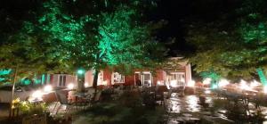 a group of tables and chairs in front of a house at night at ΠΕΡΙ ΑΝΕΜΩΝ in Zérvi