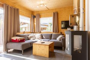 een woonkamer met een bank en een open haard bij Feriendorf Murau by ALPS RESORTS in Murau