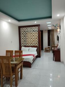 um quarto com uma cama, uma mesa e cadeiras em OYO NGUYỄN TRUNG HOTEL em Vung Tau