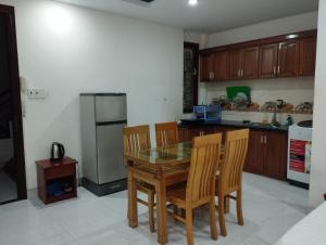 uma cozinha com uma mesa e cadeiras e um frigorífico em OYO NGUYỄN TRUNG HOTEL em Vung Tau