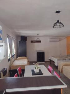 een woonkamer met een tafel en een kamer met 2 bedden bij Los Ceibos dpto para 4 personas in Estancia Vieja