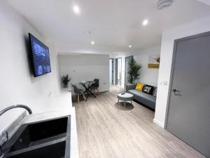 a living room with a couch and a table at BL 1 Bedroom Apartment, Town Centre, Secure gated parking option, Modern, fresh and spacious living, Netflix ready TV, Wifi in Wellingborough