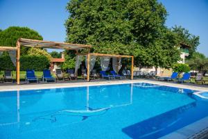 una grande piscina con sedie blu e baldacchino di Villa Vasiliadi a Vourvourou