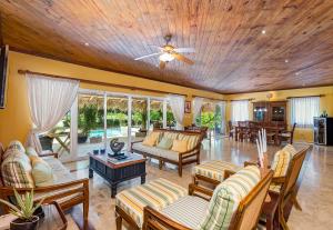 uma sala de estar com mobiliário e uma ventoinha de tecto em A Golf Lover's Dream Villa with 4 Bedrooms, Pool, Jacuzzi, and Maid em Punta Cana