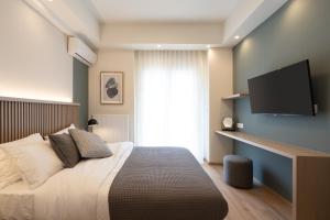 een slaapkamer met een bed en een flatscreen-tv bij Newly Renovated 2 Bedroom Apartment, 5min to metro in Athene