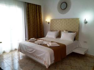 a bedroom with a large bed with towels on it at Atalos Suites in Kamari