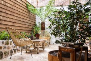 a patio with two chairs and a table and plants at LA BLACK ROOM / Les suites romantiques à Honfleur centre historique in Honfleur