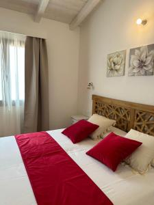 a bedroom with a large bed with red pillows at Maria Caderina Green Village in Posada