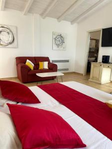 Schlafzimmer mit einem roten und weißen Bett und einem Sofa in der Unterkunft Maria Caderina Green Village in Posada